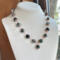 Moss agate beads in shades of teal, green and blue are linked by wire wrapping to form a necklace with copper clasp. 