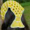 A woman with dark brown hair wearing a mermaid tail shaped crochet hair bandana that has yellow scales with mint green outlines.