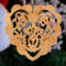A handmade wooden Victorian-style fretwork floral heart Christmas tree ornament, featuring intricate cutout floral patterns in a heart shape, with a warm natural wood finish.