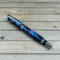 Chrome rollerball pen with purple, pink, and blue confetti ribbons