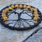 bottom view of black wire roots attached to black yarn wrapped metal hoop creating a aspooky tree of life