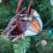 Cardinal stained glass ornament shown close up in a Christmas tree.