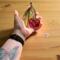 Cherry stained glass ornament being held for size reference. Approximately 4" by 4".