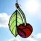 Cherry stained glass ornaments made or varying shades of red and green glass. Backdrop is of a blue sky with white puffy clouds on a sunny day.