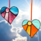 Heart-sun stained glass ornaments hanging in front of a blue sky with white puffy clouds, background.