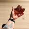 Sugar Maple Leaf stained glass ornament being held for size reference. 5"x5".