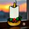 Candle stained glass ornament- candle is made with white glass and has a yellow flame with a brown base. A little holly with two leaves and three red berries sits at the base.