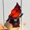 Cardinal Stained Glass Night Light- sitting on a brown glass branch with a green lampworked leaf, cardinal is made of bright red glass.