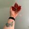 Red Maple Leaf stained glass ornament being held for size reference. Approximately 4" x 4".