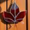 Red Maple Leaf stained glass ornament hanging on a barn wall.