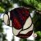 Bulldog stained glass ornament in brindle shown hanging on a Christmas tree.