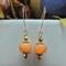 Festive handmade orange agate pumpkin-shaped earrings with gold accents and 14k gold-filled wires, about 2 inches long.