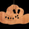 Handmade wooden Christmas tree ornament shaped like a cowboy hat, featuring a sprig of holly tucked into the hat band, star-shaped leaf cutouts, and round berry accents.
