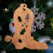 Handmade wooden Christmas tree ornament shaped like a cowboy boot, featuring a sprig of holly On the side of the boot, and round berry accents.