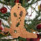 Handmade wooden Christmas tree ornament shaped like a cowboy boot, featuring a sprig of holly On the side of the boot, and round berry accents.