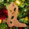 Handmade wooden Christmas tree ornament shaped like a cowboy boot, featuring a sprig of holly On the side of the boot, and round berry accents.