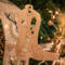 Handmade wooden Christmas tree ornament shaped like a cowboy boot, featuring a sprig of holly On the side of the boot, and round berry accents.