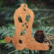 Handmade wooden Christmas tree ornament shaped like a cowboy boot, featuring a sprig of holly On the side of the boot, and round berry accents.