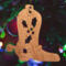 Handmade wooden Christmas tree ornament shaped like a cowboy boot, featuring a sprig of holly On the side of the boot, and round berry accents.