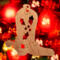Handmade wooden Christmas tree ornament shaped like a cowboy boot, featuring a sprig of holly On the side of the boot, and round berry accents.