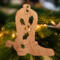 Handmade wooden Christmas tree ornament shaped like a cowboy boot, featuring a sprig of holly On the side of the boot, and round berry accents.