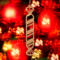 Handmade wooden Christmas tree ornament shaped like a peppermint stick with diagonal stripes, crafted from light-colored wood with flared decorative ends.