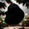 Pomeranian stained glass ornament in black- shown hanging on a Christmas tree.