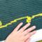 A close up of one of the yellow swirls that appear above and below the quote. The maker's hand is in the photo for size context. 