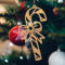 Handmade wooden Christmas tree ornament shaped like a curved candy cane with intricate stripe cutouts, accented by a delicate bow and crafted from natural light colored wood tones.