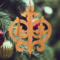 Intricate Victorian-style fretwork Christmas tree ornament handcrafted from natural hardwood with visible wood grain, showcasing symmetrical curls, loops, and ornate cut-out designs.