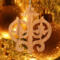 Intricate Victorian-style fretwork Christmas tree ornament handcrafted from natural hardwood with visible wood grain, showcasing symmetrical curls, loops, and ornate cut-out designs.