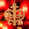 Intricate Victorian-style fretwork Christmas tree ornament handcrafted from natural hardwood with visible wood grain, showcasing symmetrical curls, loops, and ornate cut-out designs.