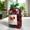 Irish Twins Apple Cinnamon Potpourri bag, green ribbon, in sunlit room with plants by a window.