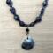 Frontal view of deep blue sodalite beads, Czech crystals, and ceramic shell pendant with blue-brown ridges