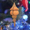 Handcrafted miniature wooden birdhouse ornament shaped like an icecicle with a pointed roof and base, featuring a rounded entrance hole and a perched bird, and made from reclaimed hardwoods finished with a satin shellac.