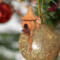 Handcrafted miniature wooden birdhouse ornament shaped like an icecicle with a pointed roof and base, featuring a rounded entrance hole and a perched bird, and made from reclaimed hardwoods finished with a satin shellac.