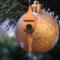 Handcrafted miniature wooden birdhouse ornament shaped like an icecicle with a pointed roof and base, featuring a rounded entrance hole and a perched bird, and made from reclaimed hardwoods finished with a satin shellac.