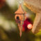 Handcrafted miniature wooden birdhouse ornament shaped like an icecicle with a pointed roof and base, featuring a rounded entrance hole and a perched bird, and made from reclaimed hardwoods finished with a satin shellac.