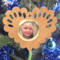 Wooden heart-shaped ornament with scalloped edges and an oak grain finish, featuring a removable round gold frame that holds a photo of a smiling blonde child.
