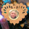 Wooden heart-shaped ornament with scalloped edges and an oak grain finish, featuring a removable round gold frame that holds a photo of a smiling blonde child.