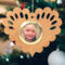 Wooden heart-shaped ornament with scalloped edges and an oak grain finish, featuring a removable round gold frame that holds a photo of a smiling blonde child.