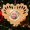 Wooden heart-shaped ornament with scalloped edges and an oak grain finish, featuring a removable round gold frame that holds a photo of a smiling blonde child.