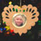 Wooden heart-shaped ornament with scalloped edges and an oak grain finish, featuring a removable round gold frame that holds a photo of a smiling blonde child.
