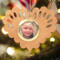 Wooden heart-shaped ornament with scalloped edges and an oak grain finish, featuring a removable round gold frame that holds a photo of a smiling blonde child.