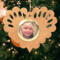 Wooden heart-shaped ornament with scalloped edges and an oak grain finish, featuring a removable round gold frame that holds a photo of a smiling blonde child.
