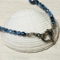 A closeup of toggle clasp and Czech crystals placed on a white seashell