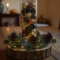Rustic handmade centerpiece with pinecones and evergreen sprigs glowing under soft lights; artisan decor for cozy gatherings.