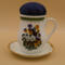 This is a front view of the pincushion attached to the saucer. It clearly shows the vibrancy of the bouquet of pansies.