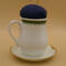 This is the backside of the pincushion which is plain white. If you look closely at the bottom of the handle, you can see the lace leaves.