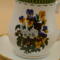 This is a closeup of the vibrant bouquet of pansies. It also shows the gold trim around the base of the cup.